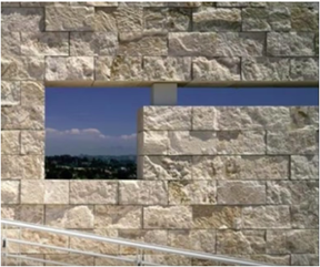 A space opens up in a  travertine wall to see the vista beyond